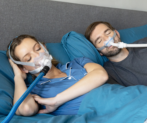Couple wearing CPAP masks in bed